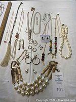 Full view of assorted costume jewelry laid out on table showing variety of necklaces and earrings