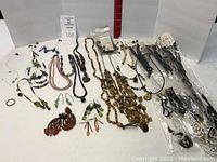 Overview of assorted beaded and natural jewelry laid out including necklaces, earrings, and bracelets.