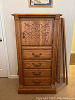 Full front view of wooden lingerie chest showing carved door, four lower drawers, and side panels.