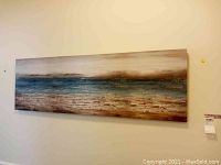 Large canvas wrapped print showing abstract seascape in earthy tones and blue colors.