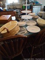 Overview of bakeware and kitchen items on kitchen island, including wooden basket, pie plates, cutting boards, and ice bucket.