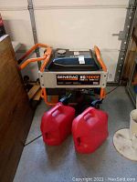 Front view of generator and two red gas cans on garage floor