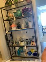 Full view of the metal shelving unit with glass shelves, empty, showing size and structure.