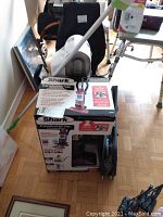 Photo showing Shark Transformer Vacuum with its box, handle and main body visible in red and black.