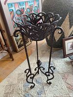 Side angle photo showing full stand height, floral design top, and curled legs.