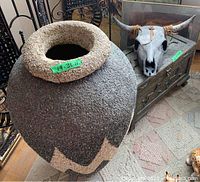 Overall view of vase, wooden chest, and ceramic skull grouped on floor