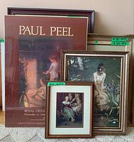 Four framed artworks arranged leaning against a wall including Paul Peel poster, nude woman classical painting, and two smaller prints