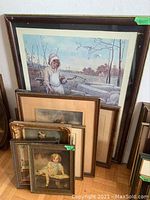 Group of 8 framed vintage portrait prints leaning against wall, various sizes and frame styles visible