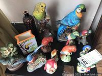 Top-side view showing various bird figurines, ceramic vases, and decorative pieces arranged on surface