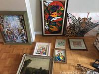 Group photo of all eight pieces of wall art, framed and unframed, showing various sizes and styles on wood floor.
