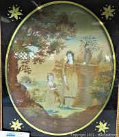 Close-up image of the oval artwork showing a woman and child near a tree and a pedestal with flowers. The artwork is bordered by gold accents on a black background.