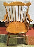 Front view of the Conant Ball Windsor wooden chair showing the curved top rail, spindle backrest, and armrests.
