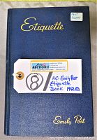 Front cover of the blue hard cover book with gold embossed text: Etiquette, Emily Post, and a label indicating it is the 1942 edition.