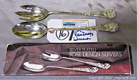 Photo showing the silver plated rose design serving fork and spoon laid out next to the original box labeled 'Silver Plated Rose Design Servers'.