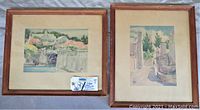 Pair of framed watercolor paintings by Adolf Treidler, showing aged wood frames and mats, visible wear and discoloration.