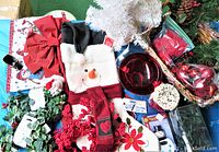 Full overview of assorted Christmas lot contents including white tree, stockings, basket, bow, garland wreath, red ornaments, and misc decorations.