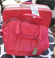 Overall view of the two-piece hot pink Samsonite luggage, one hard case and one soft carry-on bag, stacked and showing color, size, and condition