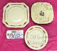 Top side of the plates showing Royal China and Johnson Bros plates with red floral and gold trim designs.