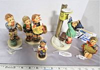 Full lot of five Hummel figurines arranged with labels visible