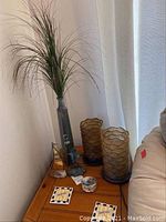 Full view of the corner table showing decorative items including the vase with artificial grass, small trinket box, and part of the frog candle holder