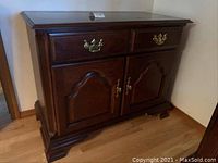 Side view of the dark wooden Keller sideboard showing drawer and door design with brass handles.