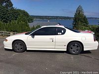 Side profile of white coupe with red stripes, tinted windows