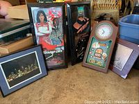 Five items arranged together on floor: two Snap-on and GM clocks, casino clock, and two framed arts