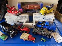 Overview of collectible model trucks including various tow trucks in multiple colors, some boxed and some loose, with Texaco branding visible