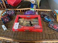 Overall view of multiple collectible diecast trucks, including Racing Champions Motor Trend 75th Anniversary set and several individual models in packaging and display case.