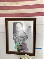 Framed portrait of James H. Doolittle with commemorative documentation attached, set against an American flag background.