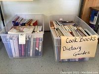 Two bins filled with assorted cookbooks and dietary guides including visible sign 'Cook Books Dietarg Guides'.