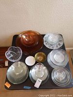 Top view of mixed glass bowls and dishes with varied shapes and colors including amber and clear glass.