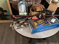 Photo showing vintage tools including hand drills, a wooden cane, vintage baseball glove, and a boxed yard of ale glass.