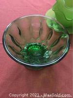 Translucent green footed bowl showing scalloped design and patterned base.