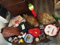 Lot overview showing large Pez dispenser, gold pinecone decor, plastic containers, and toys