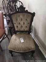 Front view of Eastlake style upholstered chair showing diamond tufted back and striped fabric seat.