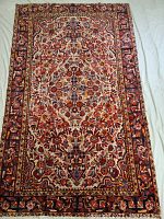 Full view of rug laid flat showing front floral medallion design and border