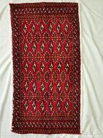 Full view of the Persian Turkman rug showing the complete geometric traditional pattern with red background and borders.