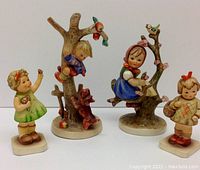Group shot of all four Hummel figurines on white background