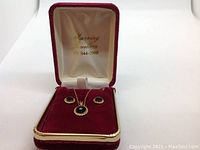 Full set of earrings and necklace in red velour-lined box with lid open