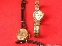 Two watches on red background, showing both items