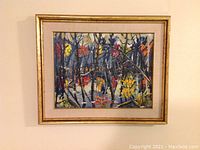Full view of framed painting showing gold wood frame, fabric mat and autumn woodland scene.