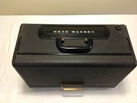 Top view showing black textured case with carry handle and 'Wave Magnet' label.