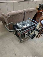 Side view of generator on concrete floor, showing frame, wheels and control panel