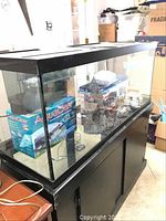 Front view of aquarium on stand showing tank, stand and accessories inside