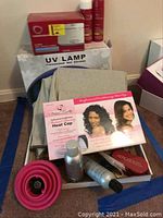 Photo showing various salon and beauty items including UV lamp box, Mutual Beauty Heat Cap box, red jewelry cleaner, hair care bottles, and a pink cylindrical item.