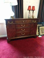 Full front view of Henredon mahogany wood cabinet with lamps on top and carpeted floor
