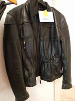 Front view of black leather motorcycle jacket showing zipper and pockets