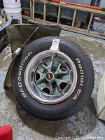 Photo showing one complete BFGoodrich Radial T/A tire mounted on Oldsmobile rally rim with center cap and license plate holder
