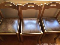 Set of 3 wooden dining chairs with dark brown leatherette cushioned seats, showing top and backrest details